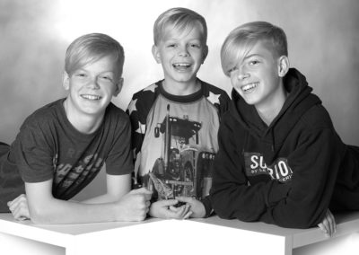 Børnefoto af 3 glade søskende i sorthvid