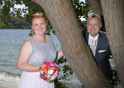 Bryllups foto af brudepar ved træ